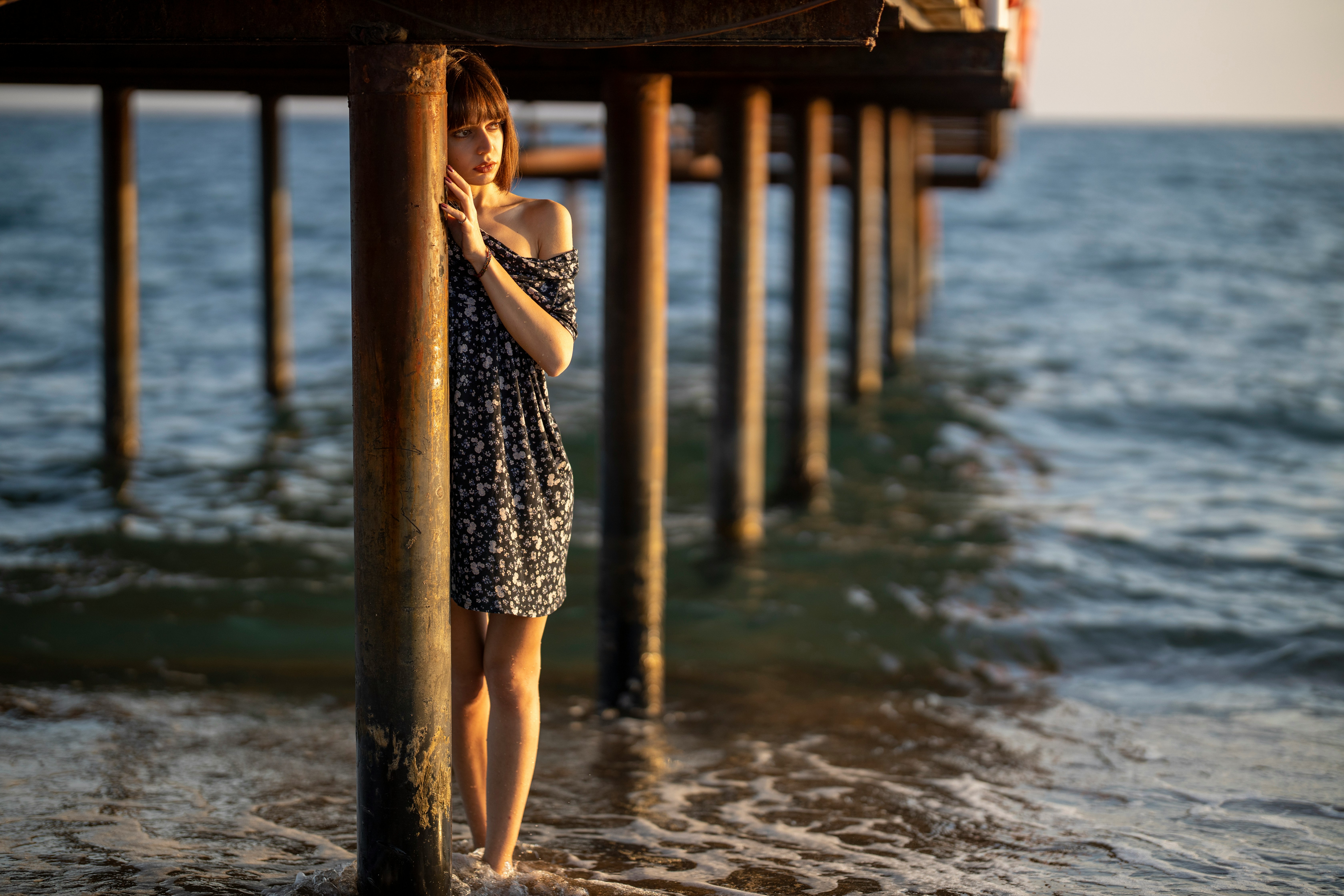 woman in black and white dress standing on wooden dock during daytime